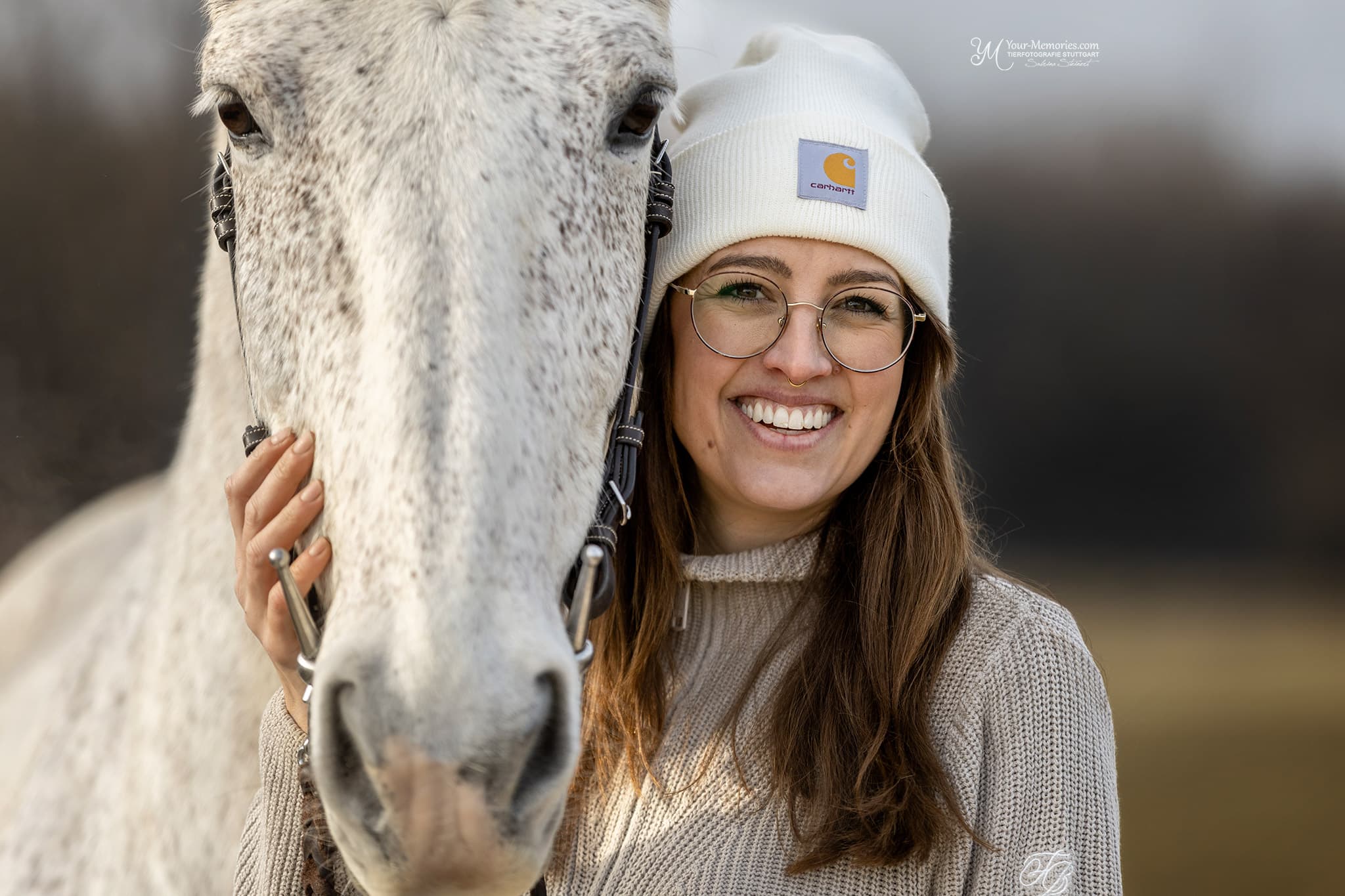 Sandra Putzke steht neben einem Pferd und lächelt